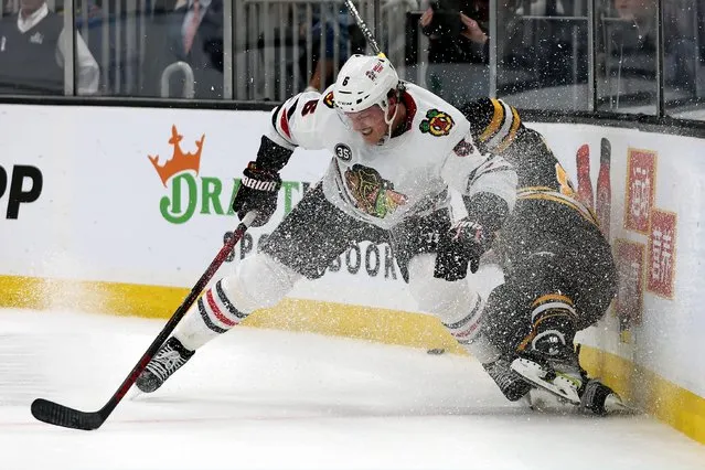 Jake McCabe #6 of the Chicago Blackhawks checks David Pastrnak #88 of the Boston Bruins into the boards during the third period at TD Garden on March 10, 2022 in Boston, Massachusetts. The Bruins defeat the Blackhawks 4-3. (Photo by Maddie Meyer/Getty Images)
