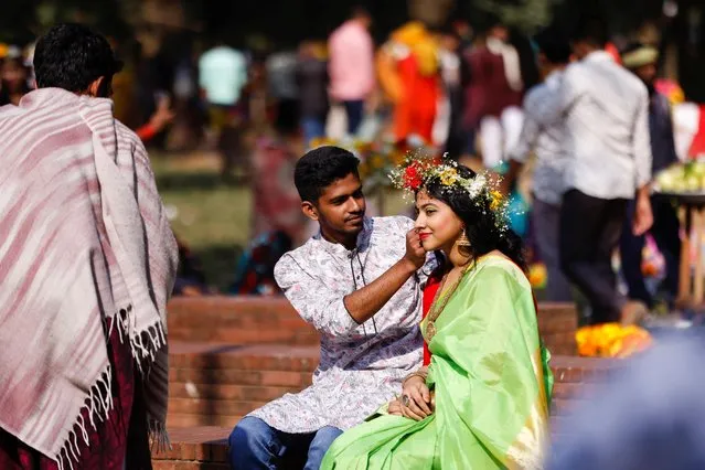 A man fixes a flower wreath on a girl's head on Valentine's Day in Dhaka, Bangladesh on February 14, 2022. (Photo by Mohammad Ponir Hossain/Reuters)