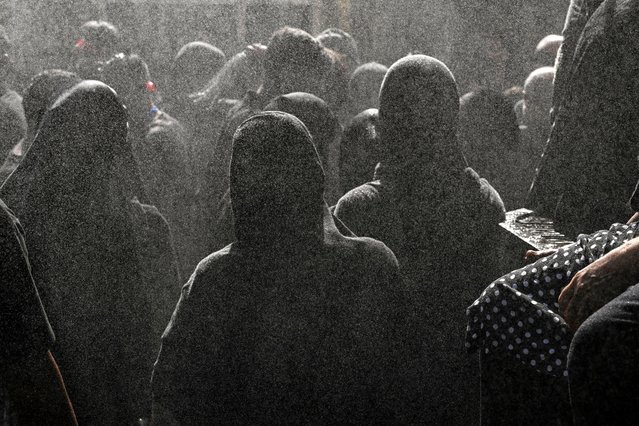 Rose water is sprayed over Kashmiri Shiite Muslim women mourners watching a religious procession on the tenth day of Ashura in the Islamic month of Muharram in Srinagar on July 17, 2024. (Photo by Tauseef Mustafa/AFP Photo)