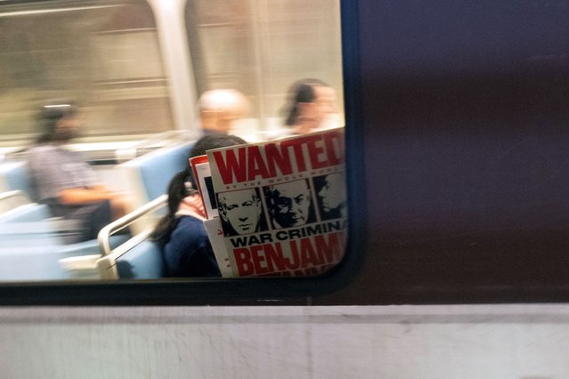 A pro-Palestinian protester holds a sign inside a bus during a demonstration outside the Watergate Hotel following Israeli Prime Minister Benjamin Netanyahu’s address during a joint session of congress, in Washington, DC on July 24, 2024. (Photo by Matthew Hatcher/AFP Photo)