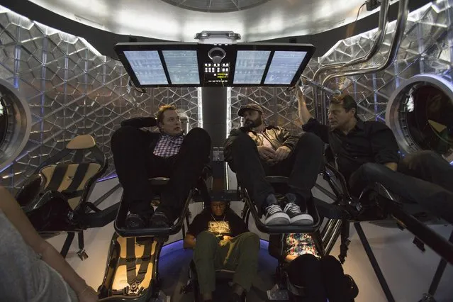 SpaceX CEO Elon Musk (L) sits with guests inside the Dragon V2 spacecraft after it was unveiled in Hawthorne, California May 29, 2014. REUTERS/Mario Anzuoni