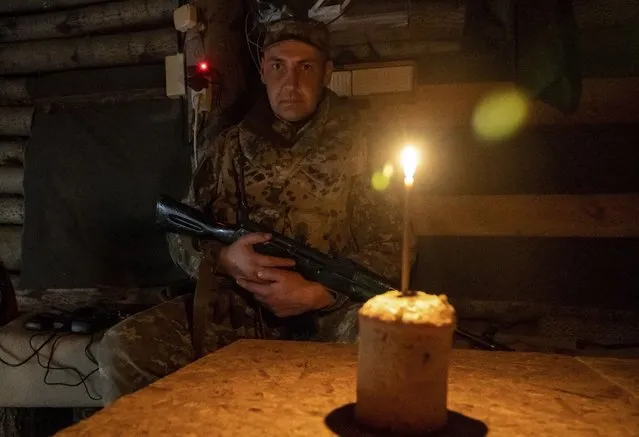 Ukrainian Territorial Defense fighter sits in a shelter with an Easter Cake near Kharkiv, Ukraine, 24 April 2022, amid Russian invasion. Ukrainians mark orthodox Easter today. Easter is celebrated around the world by Christians to mark the resurrection of Jesus Christ from the dead and the foundation of the Christian faith. (Photo by Vasiliy Zhlobsky/EPA/EFE)