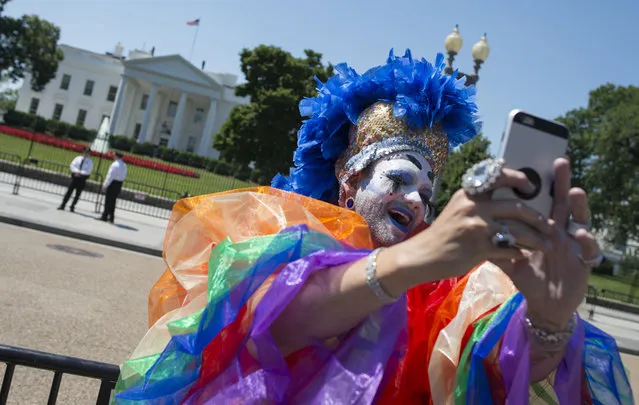 A Drag Queen takes a photo as LGBT members and their supporters walk past the White House during the Equality March for Unity & Pride parade in Washington DC, June 11, 2017. (Photo by Andrew Caballero-Reynolds/AFP Photo)