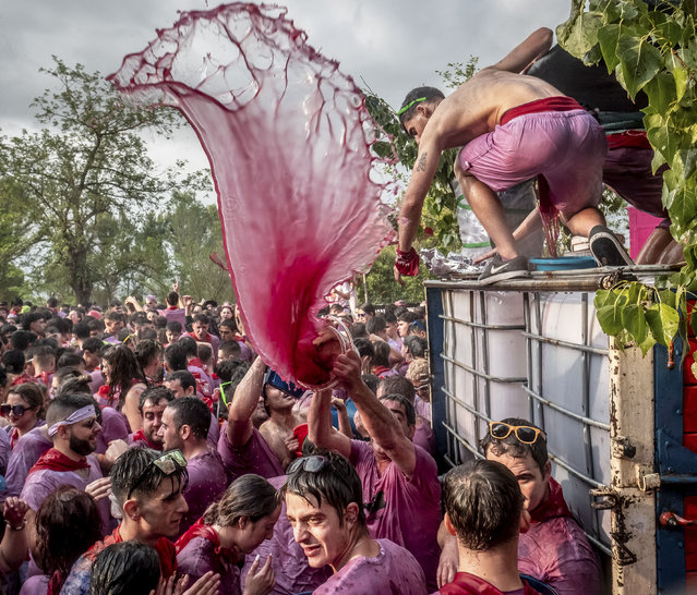 People take part in the traditional “Wine Battle” in the village of Haro, in La Rioja, northern Spain, early morning 29 June 2023. Some 6,000 people wearing white clothes and a red scarf took part in the traditional 'christening' of the Wine Battle, throwing each other with around 30,000 liters of wine. (Photo by Fernando Díaz/EPA/EFE/Rex Features/Shutterstock)