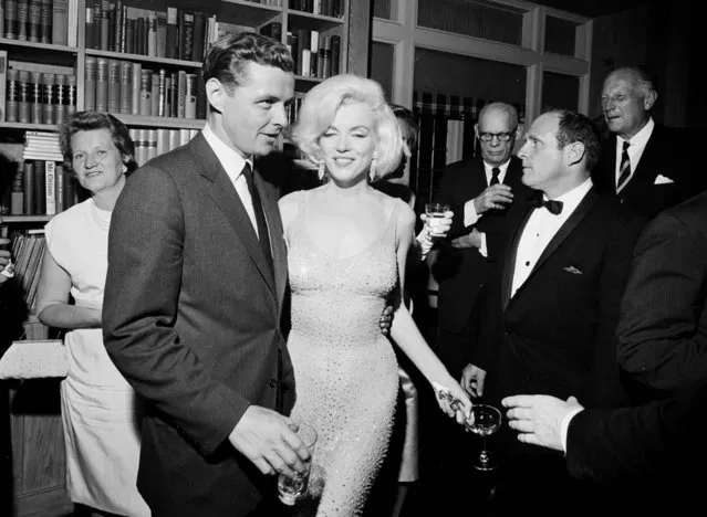 In this May 19, 1962 photo provided by the John F. Kennedy Presidential Library and Museum, actress Marilyn Monroe wears the iconic gown that she wore while singing “Happy Birthday” to President John F. Kennedy at Madison Square Garden, during a reception in New York City. Standing next to Monroe is Steve Smith, President Kennedy's brother-in-law. Julien's Auctions will offer Monroe's gown at auction in Los Angeles on Nov. 17, 2016. (Photo by Cecil Stoughton/White House Photographs, John F. Kennedy Presidential Library and Museum via AP Photo)