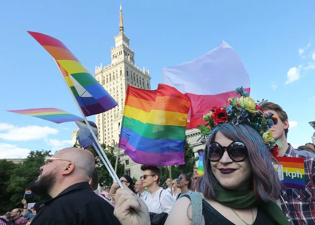 Thousands of Warsaw residents with rainbow flags walk in a colorful annual Equality Parade to show their support for sexual minority groups  in Warsaw, Poland, Saturday, June 11, 2016. The 16th parade Saturday is held at a time when views concerning minorities are getting radicalized under a right-wing government that took office in November. A visible police presence accompanied the march. (Photo by Czarek Sokolowski/AP Photo)