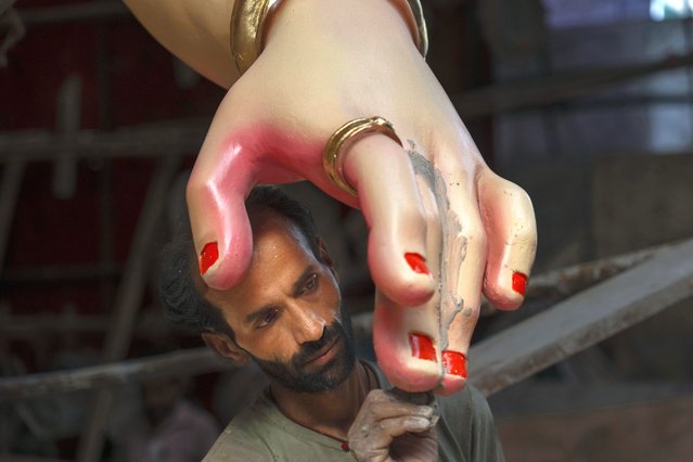 An artist works on an idol of the elephant-headed Hindu god Ganesha inside a workshop ahead of Ganesh Chaturthi festival in Mumbai, India, Wednesday, September 4, 2024. (Photo by Rafiq Maqbool/AP Photo)