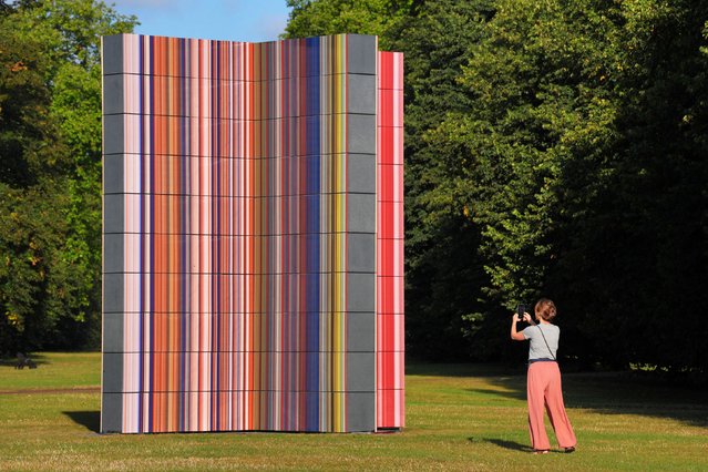 A person takes a photo of Gerhard Richter's art installation, Strip-Tower, while walking through Hyde Park, London on Friday, August 16, 2024. (Photo by Jonathan Brady/PA Images via Getty Images)