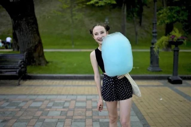 A girl holds cotton candy at a square in Kyiv, Ukraine, Friday, June 10, 2022. (Photo by Natacha Pisarenko/AP Photo)