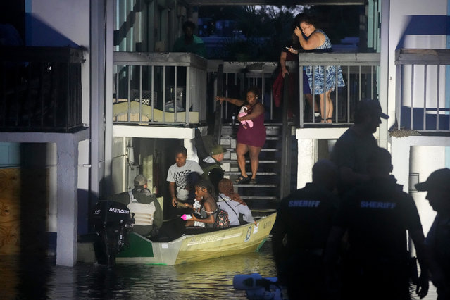 Residents are rescued from an their second story apartment complex in Clearwater that was flooded from and overflowing creek due to Hurricane Milton on October 10, 2024 in Florida. Hurricane Milton felled trees, tore roofs off buildings, and flooded streets, leaving residents of the Florida coast surveying a trail of destruction on October 10, 2024, in a state still reeling from another massive storm two weeks earlier. (Photo by Bryan R. Smith/AFP Photo)