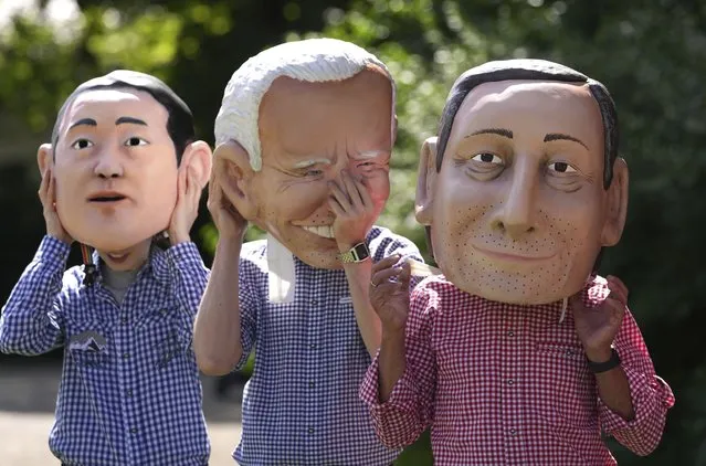 Activists from Oxfam wear giant heads depicting G7 leaders during a demonstration in Munich, Germany, Saturday, June 25, 2022. The G7 Summit will take place at Castle Elmau near Garmisch-Partenkirchen from June 26 through June 28, 2022. Leaders depicted from left, Japan's Prime Minister Fumio Kishida U.S. President Joe Biden and Italy's Prime Minister Mario Draghi. (Photo by Matthias Schrader/AP Photo)