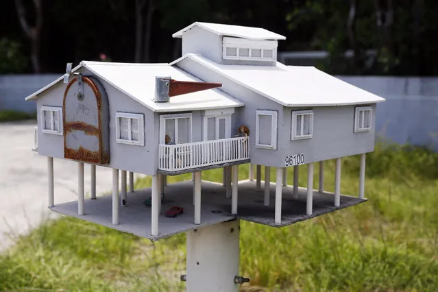 A mailbox in the shape of a house with a veranda and a parking lot is seen along the highway US-1 in the Lower Keys near Key Largo in Florida, July 10, 2014. (Photo by Wolfgang Rattay/Reuters)