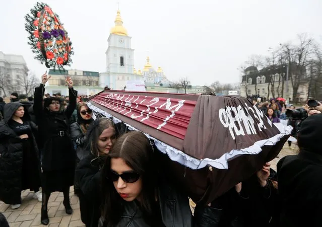 Anti-feminist activists carry a coffin as they stage a performance “Funeral of feminism” on the International Women's Day in Kiev, Ukraine on March 8, 2020. The writing on the coffin reads: “Feminism”. (Photo by Valentyn Ogirenko/Reuters)