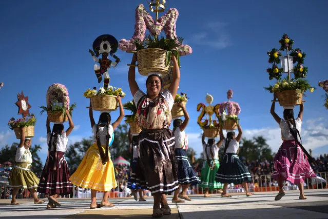 Regional dancers perform at the Guelaguetza Festival in Cuilapam de Guerrero, Oaxaca State, Mexico, on July 25, 2022. The annual Guelaguetza Festival brings together music, dance, gastronomy and crafts from different ethnic groups and tribes from the state of Oaxaca. (Photo by Pedro Pardo/AFP Photo)