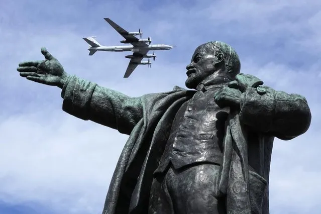 Tupolev Tu-142MK, a Soviet and Russian maritime reconnaissance and anti-submarine warfare aircraft flies above a statue of Soviet Union founder Vladimir Lenin during a rehearsal of the Naval parade in St.Petersburg, Russia, Thursday, July 28, 2022. The celebration of Navy Day in Russia is traditionally marked on the last Sunday of July and will be celebrated on July 31 this year. (Photo by Dmitri Lovetsky/AP Photo)