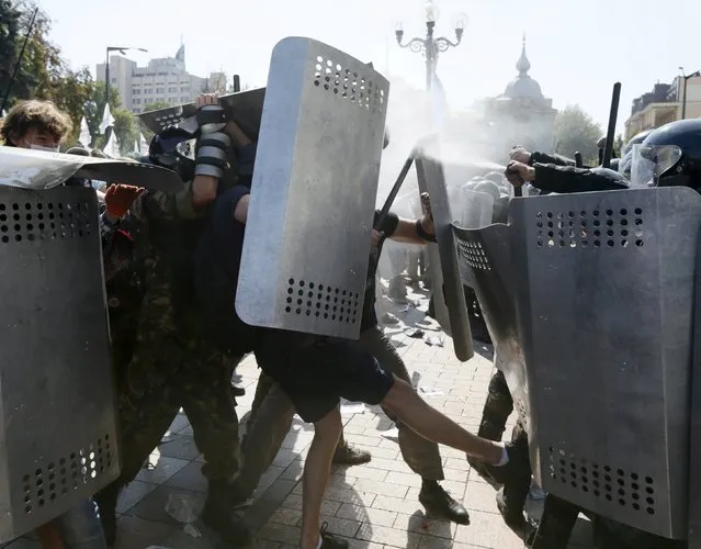 Demonstrators, who are against a constitutional amendment on decentralization, clash with police outside the parliament building in Kiev, Ukraine, August 31, 2015. (Photo by Valentyn Ogirenko/Reuters)