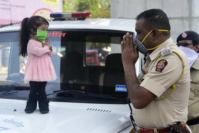 Guinness world record holder of the world's smallest living woman, Jyoti Amge (L), greets a police officer as she appeals citizens to stay inside their homes during a government-imposed nationwide lockdown as a preventive measure against the COVID-19 coronavirus, in Nagpure, India on April 13, 2020. (Photo by AFP Photo/Stringer)