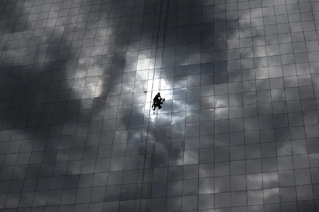 A window cleaner works on the exterior of a hotel outside the 2016 Rio Olympics Park in Rio de Janeiro, Brazil, July 18, 2016. (Photo by Stoyan Nenov/Reuters)