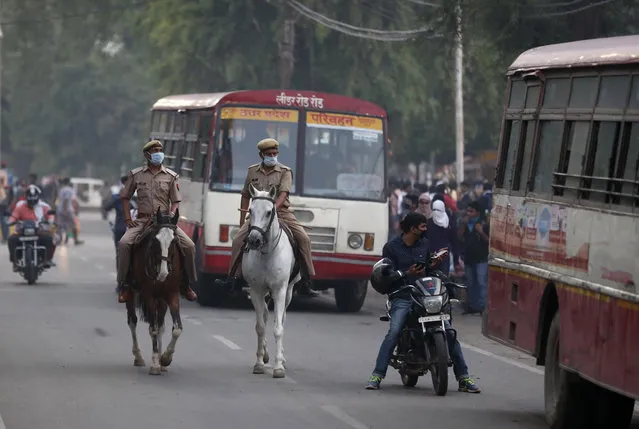 Policemen patrol as stranded students from various districts wait for transport to travel to their hometowns, during lockdown to prevent the spread of the new coronavirus in Prayagraj, India, Tuesday, April 28, 2020. India last week eased the lockdown by allowing shops to reopen and manufacturing and farming activities to resume in rural areas to help millions of poor, daily-wage earners. But the economic costs of the nationwide lockdown continue to mount in a country of 1.3 billion people. (Photo by Rajesh Kumar Singh/AP Photo)