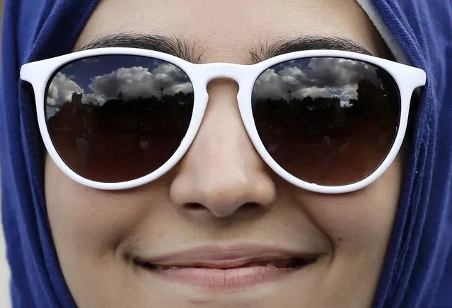 Blue sky and clouds are reflected in the sunglasses of a protester during a demonstration to express solidarity with migrants and to demand the government welcome refugees into Britain, in London, September 12, 2015. (Photo by Kevin Coombs/Reuters)