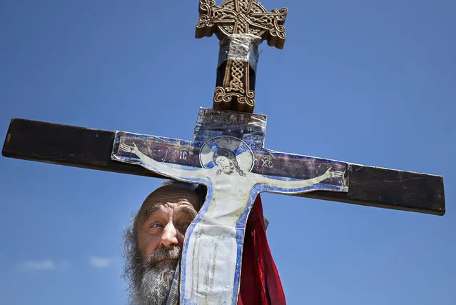 A Serbian man holds a crucifix as he takes part in a ceremony marking the historic “Battle of Kosovo” at a memorial in Gazimestan, on the outskirts of Pristina on June 28, 2020. The ceremony marks the Battle of Kosovo in 1389 when the Serbian army was defeated by the Ottoman Empire. (Photo by Armend Nimani/AFP Photo)