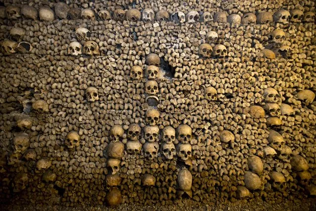 In this photo taken Tuesday, October 14, 2014, skulls and bones are stacked at the Catacombs in Paris, France. (Photo by Francois Mori/AP Photo)