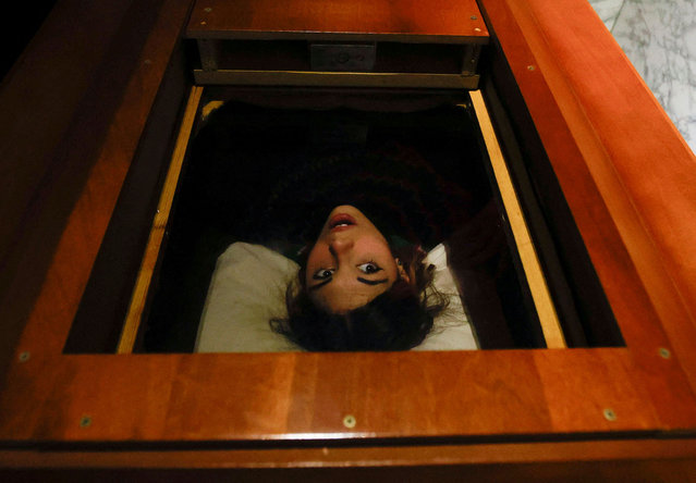 Gamer Miriam Castella is locked in a coffin while participating in an extreme escape room named Catalepsia, which takes place inside a coffin simulating her funeral and trying to escape from it by working to solve puzzles and tricks, in Barcelona, Spain, on January 18, 2024. (Photo by Albert Gea/Reuters)