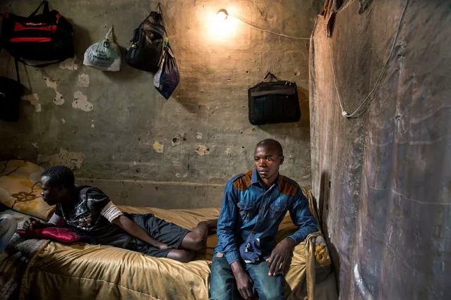 Adam, 25, from Zambia, in the small windowless room he shares with four other migrant workers. (Photo by Jonathan Torgovnik/Getty Images)