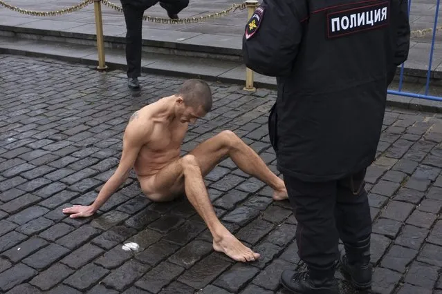 Artist Pyotr Pavlensky sits on the pavestones of Red Square during a protest action in front of the Kremlin wall in central Moscow November 10, 2013. (Photo by Maxim Zmeyev/Reuters)