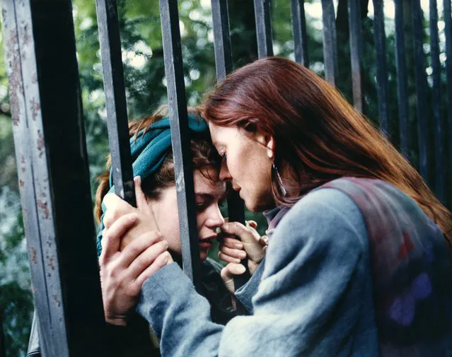 An East German mother cries as she says goodbye to her daughter as the fence of the West German embassy in Prague separates them Saturday, September 30, 1989.  The mother went back to East Germany and the daughter stayed with some 3,300 refugees who hope for emigration to the West. (Photo by Diether Endlicher/AP Photo)