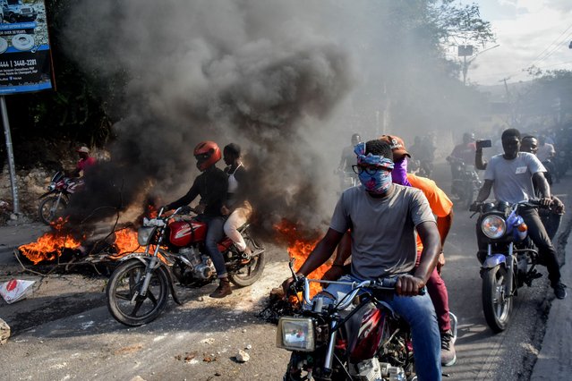 Protestors ride motorbikes past piles of burning rubbish during a demonstration in Port-au-Prince, Haiti, 06 February 2024. Several thousand people have once again taken to the streets of Port-au-Prince and several cities in the province to demand the unconditional departure of Prime Minister Ariel Henry, as the 07 February deadline for a new head of state to be sworn in approaches. (Photo by Siffroy Clarens/EPA)