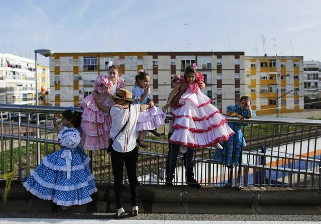 A couple and girls wearing “Sevillana” dresses take part in the Valme pilgrimage in the town of Dos Hermanas near the Andalusian capital of Seville, southern Spain, October 19, 2014. The pilgrimage takes place since 1894 and pilgrims wearing traditional Andalusian dresses accompany the Virgin on horseback, on foot or in carts in an atmosphere which combines religious fervor and divertissement. (Photo by Marcelo del Pozo/Reuters)