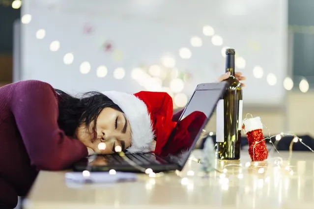 A Japanese drunk young woman is sleeping in front of computer on Christmas. (Photo by recep-bg/Getty Images)