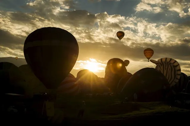 Hot air balloons lift off as the sun rises over the first day of the 2015 Albuquerque International Balloon Fiesta in Albuquerque, New Mexico, October 3, 2015. (Photo by Lucas Jackson/Reuters)