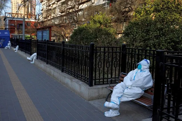 Pandemic prevention workers wait for the start of their shift to look after buildings where residents do home quarantine, as coronavirus disease (COVID-19) outbreaks continue in Beijing on December 8, 2022. (Photo by Thomas Peter/Reuters)