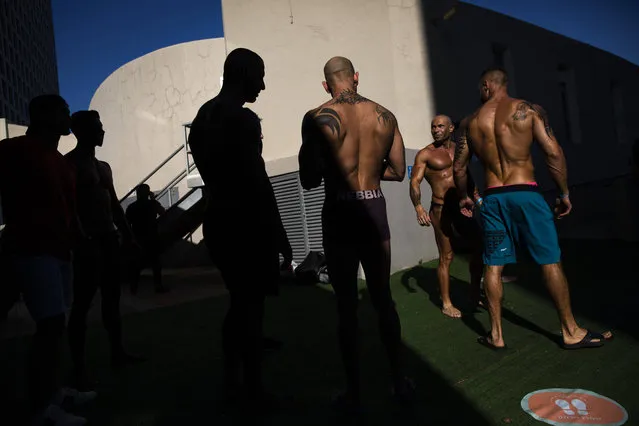 Contestants exercise backstage during the National Amateur Body Builders Association competition in Tel Aviv, Israel, Wednesday, August 19, 2020. Because of the coronavirus pandemic, this year's competition was staged outdoors in Tel Aviv. The 85 participants were required to don protective masks in line with health codes. (Photo by Oded Balilty/AP Photo)