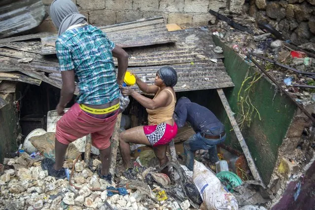 Residents look for salvage items next to the Tet Dlo river after the passing of Tropical Storm Laura in Port-au-Prince, Haiti, Sunday, August 23, 2020. (Photo by Dieu Nalio Chery/AP Photo)