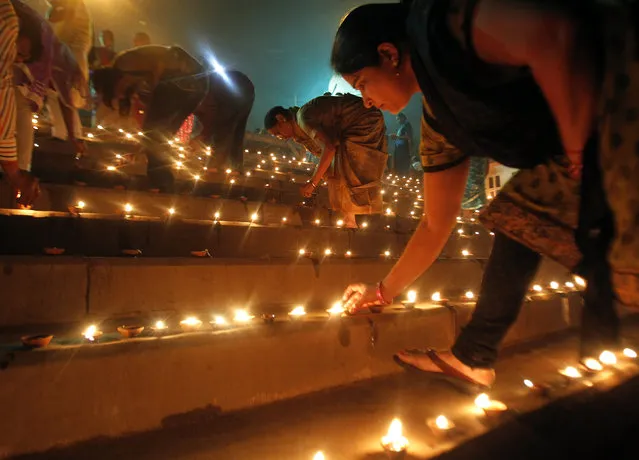 Hindu devotees light earthen oil lamps on the occasion of Dev Deepawali festival, on the banks of the river Yamuna in Allahabad November 6, 2014. (Photo by Jitendra Prakash/Reuters)