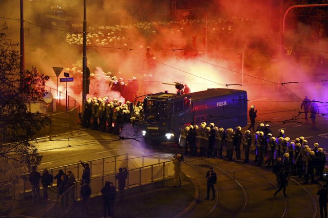 Riot policemen stand beside a water cannon as several hundred masked men who broke away from a far-right march threw stones and flares in Warsaw November 11, 2014. (Photo by Kacper Pempel/Reuters)
