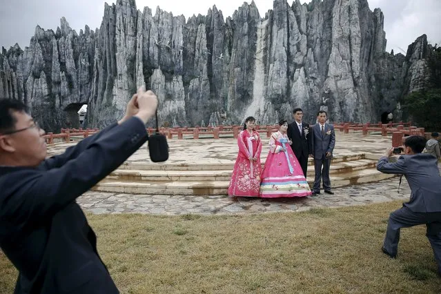 O Yang Ran and her husband Kim Chol Nam (C) are accompanied by friends during a photo session at Pyongyang Folk Park, October 11, 2015. (Photo by Damir Sagolj/Reuters)