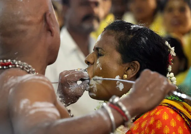 A Hindu devotee reacts as she gets her cheeks pierced with a metal skewer during the Thaipusam festival in Chennai, India, January 31, 2018. (Photo by P. Ravikumar/Reuters)