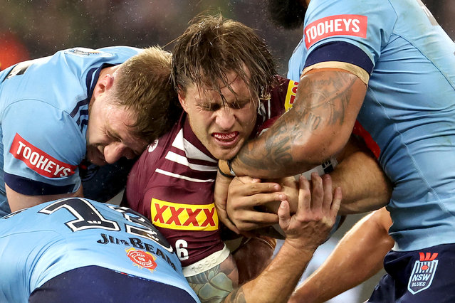 Maroons' Cameron Munster (C) is tackled by Blues defence during game two of the men's State of Origin series between Queensland Maroons and New South Wales Blues at Optus Stadium in Perth on June 18, 2025. (Photo by Colin Murty/AFP Photo)