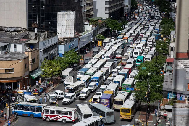 General view of a street blocked by public buses during a bus drivers' protest in Caracas, Venezuela, 21 September 2016. The drivers protested against the lack of parts and the increase of fare rates. (Photo by Miguel Gutierrez/EPA)