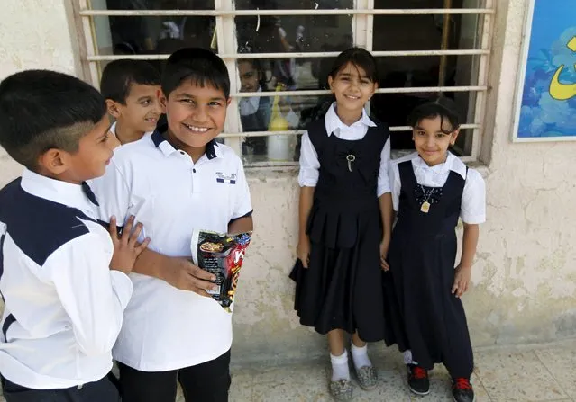 Students poses for a photograph on the first day of the new school term at a primary school in Baghdad, October 18, 2015. (Photo by Ahmed Saad/Reuters)