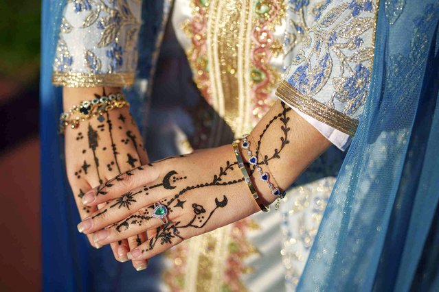 A young woman shows off her henna tattoos at the end of Eid al-Fitr prayers in Bucharest, Romania, Wednesday, April 10, 2024. Members of the Romanian Muslim community joined prayers at the Dinamo stadium in the Romanian capital, in the largest Muslim public gathering of the year. Eid al-Fitr marks the end of the holy fasting month of Ramadan. (Photo by Andreea Alexandru/AP Photo)
