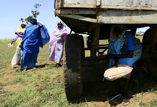 Displaced people gather to receive food provided by the United Nations' World Food Programme (WFP) during a visit by a European Union delegation, at an IDP camp in Azaza, east of Ed Damazine, capital of Blue Nile state, October 21, 2015. (Photo by Mohamed Nureldin Abdallah/Reuters)