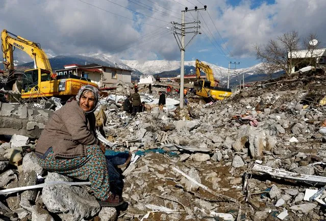 A woman sits amidst rubble and damages following an earthquake in Gaziantep, Turkey on February 7, 2023. (Photo by Suhaib Salem/Reuters)