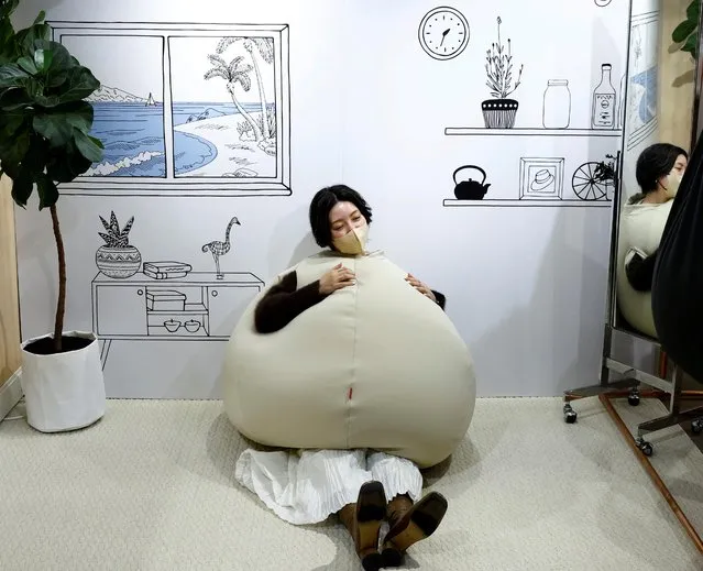 Yuu Matsuzaki, a product buyer for the Marui Group tries on the wearable beanbag during a photo opportunity at a pop-up booth of the Shinjuku Marui main department store in Tokyo, Japan on February 6, 2023. While the beanbag's onion-shaped goofy style made it a hit on Japanese social media earlier this month, the main goal was relaxation, according to Shogo Takikawa, a representative of the beanbag's manufacturer, Takikou Sewing. (Photo by Kim Kyung-Hoon/Reuters)