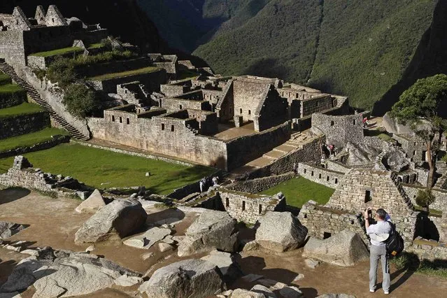 A visitor takes photos at the Inca citadel of Machu Picchu in Cusco December 2, 2014. (Photo by Enrique Castro-Mendivil/Reuters)