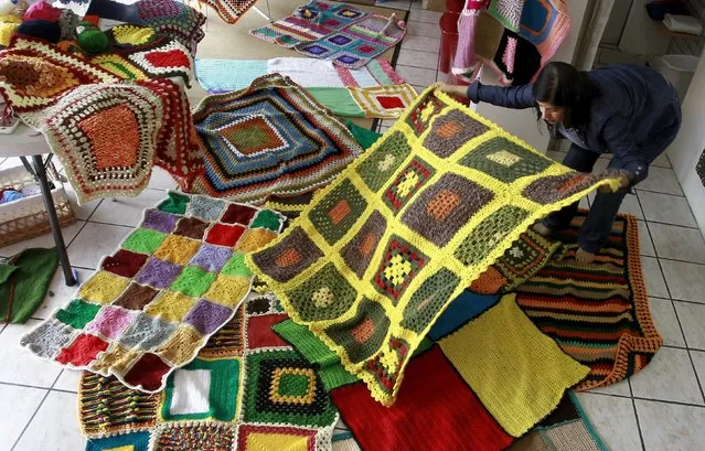 Alejandra Gutierrez displays a blanket knitted for a campaign called "A Blanket for Syria", in San Jose October 28, 2015. A group of Costa Rican women are knitting blankets of varying sizes to send to an NGO in Madrid, which will ship them to camps for displaced people inside Syria, before cold weather begins, following an appeal for help, according to local media. (Photo by Juan Carlos Ulate/Reuters)
